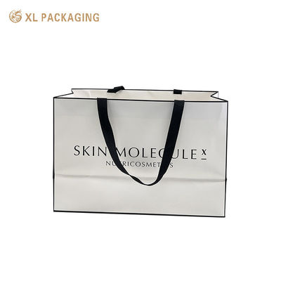 Borsa regalo in carta patinata bianca opaca di lusso con marchio personalizzato con ampio manico in nastro intrecciato nero per la vendita al dettaglio di cosmetici