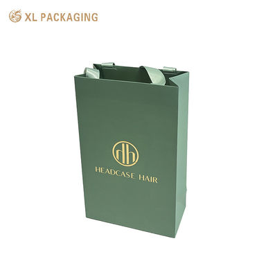 Borsa regalo personalizzata in carta patinata smerigliata verde salvia opaca con logo in lamina d'oro con ampi manici in nastro di raso in tinta
